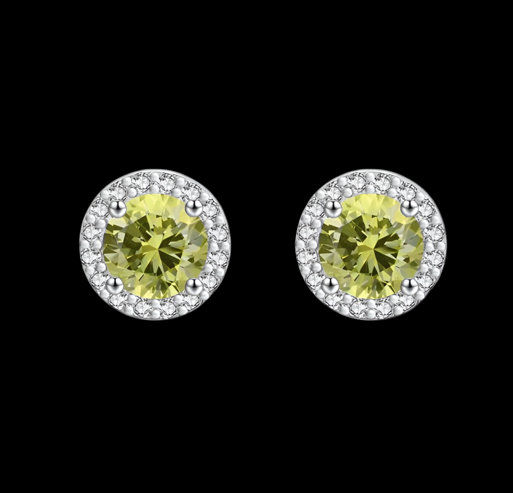 Pair of round yellow gemstone earrings with silver halo on a black background