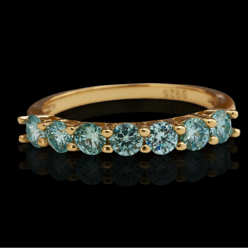 Gold ring with blue gemstones on a black background