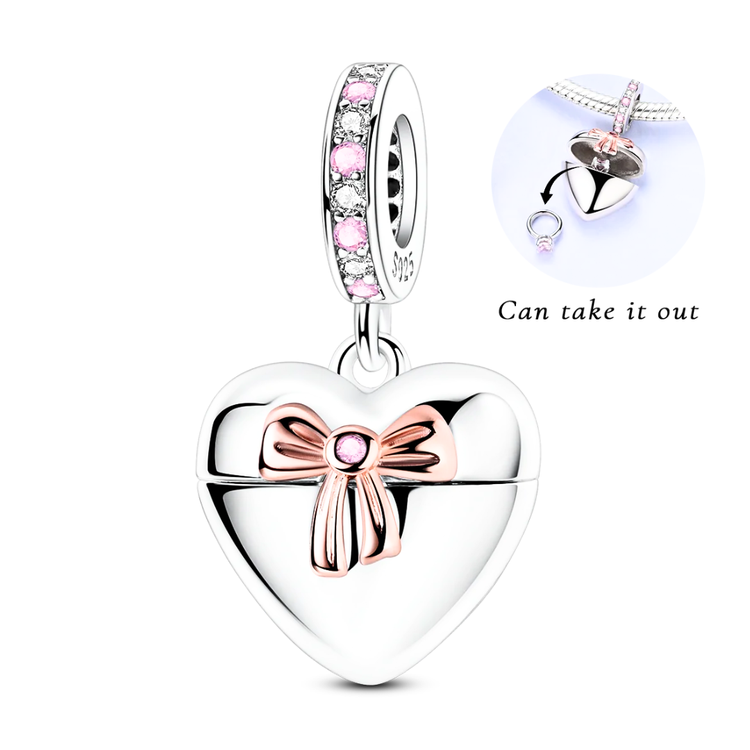 Heart-shaped pendant with a bow and pink gem on a white background