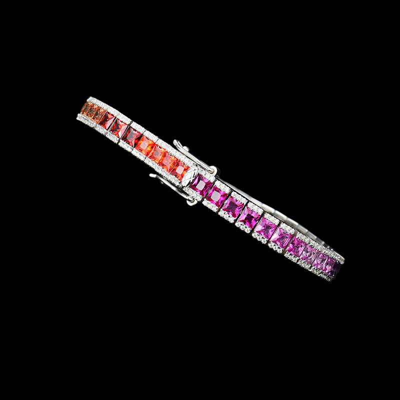 Silver bracelet with red and pink gemstones on a black background