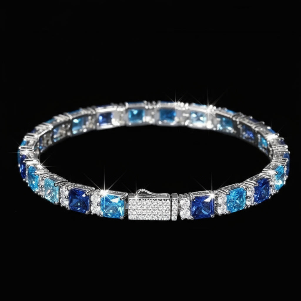 Silver bracelet with blue and clear gemstones on a reflective blue surface