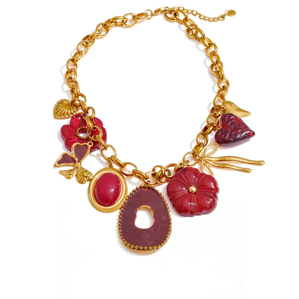 Gold bracelet with red charm pieces on a white background