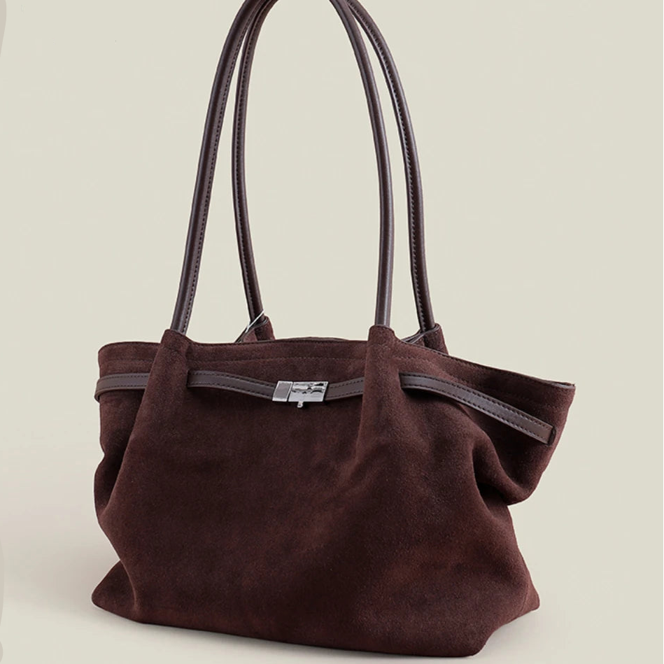 Brown suede handbag on a beige background with 'PASTE' branding.