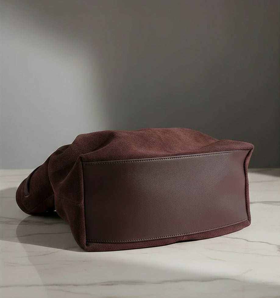 Brown leather bag on a beige background with 'PASTE' branding.