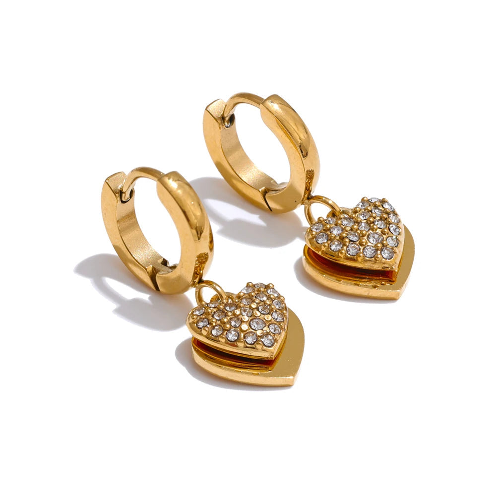 Gold hoop earrings with heart-shaped charms on a white background