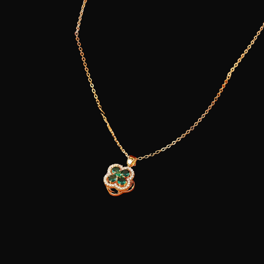 Gold necklace with a green gemstone pendant on an orange surface