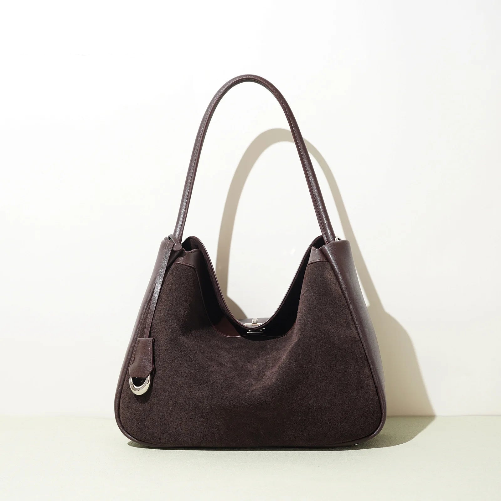 Brown handbag on a light background with 'PASTE' branding.