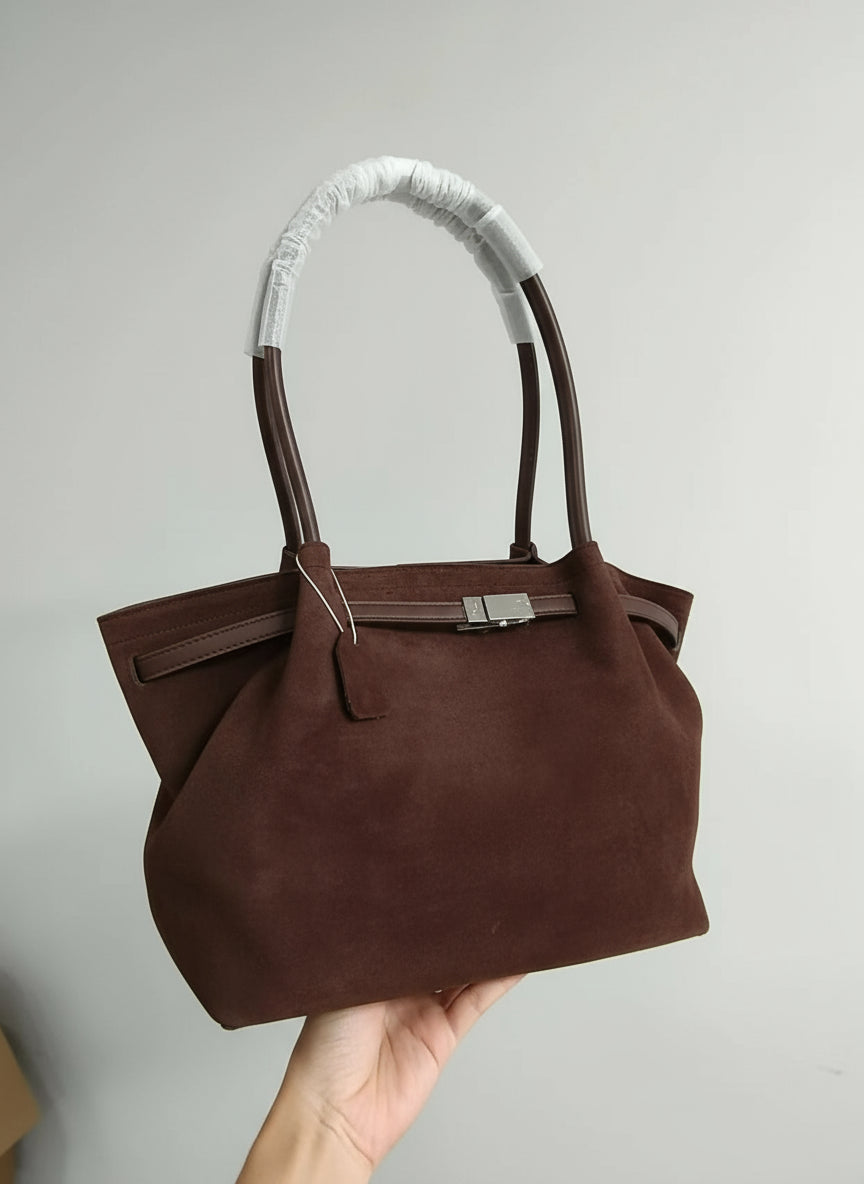 Brown handbag with white handle held by a hand against a plain background, labeled 'Real photo taken by MAPLE store'.