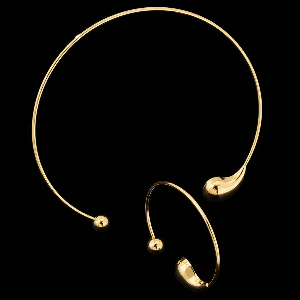 Gold choker necklace and bracelet on a white background