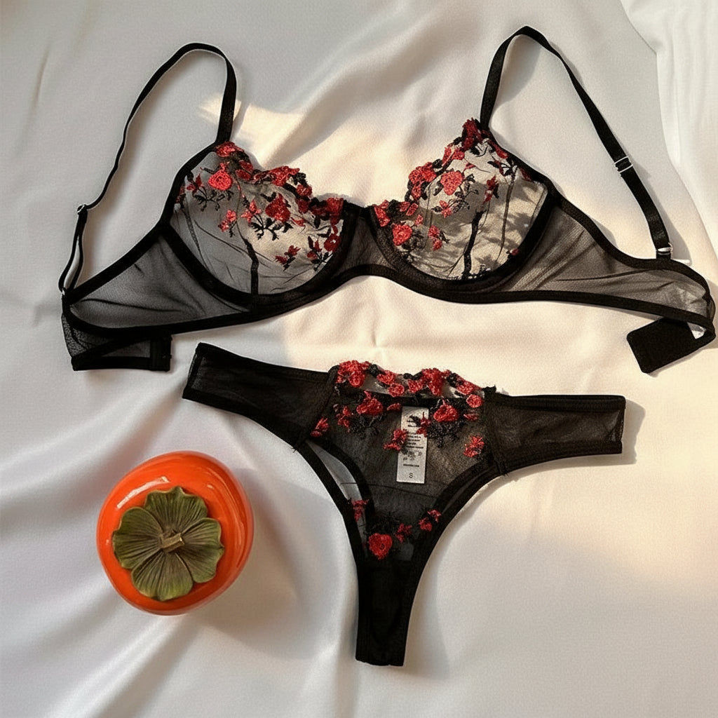 Black lingerie set with floral embroidery on a white background