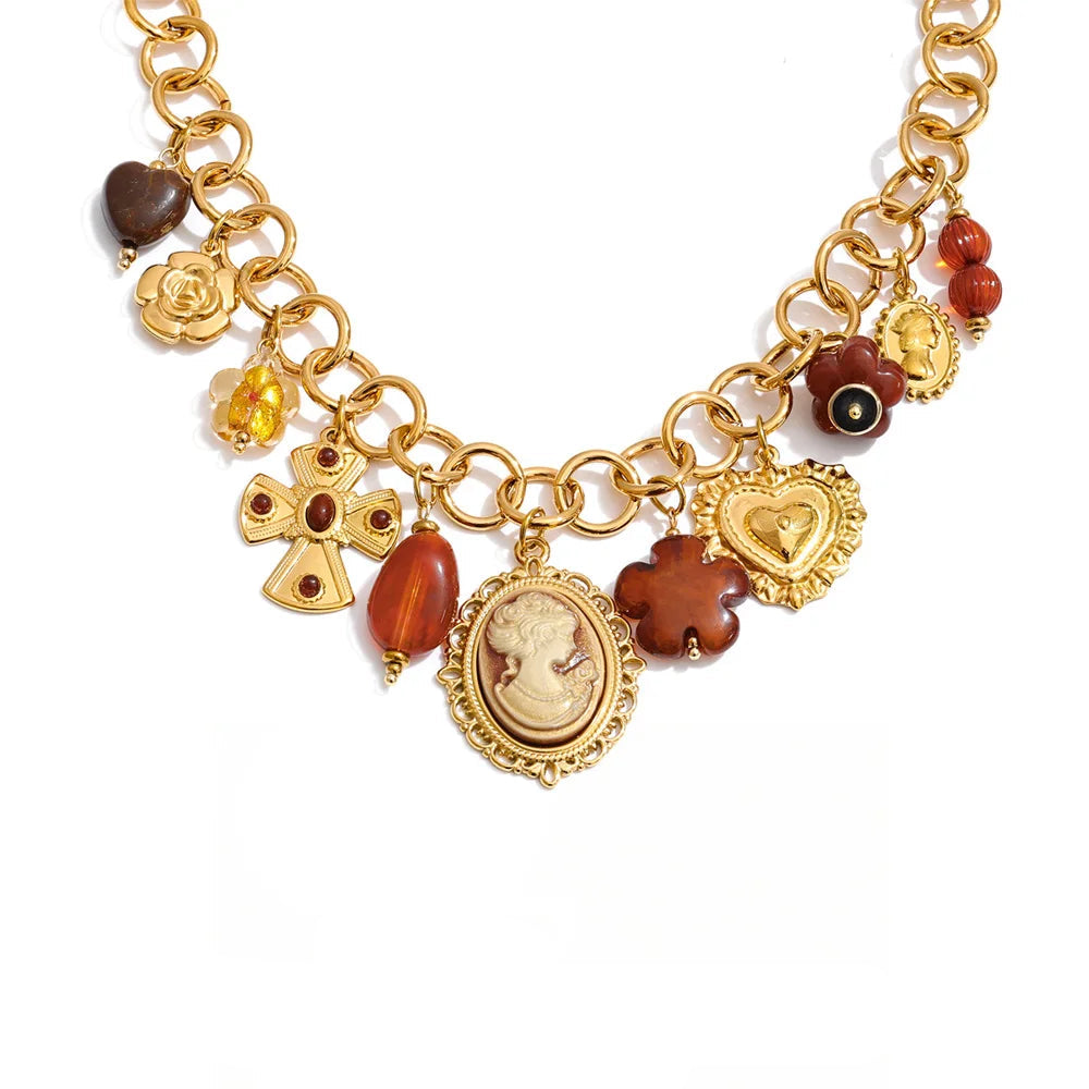 Gold necklace with various charms on a white background