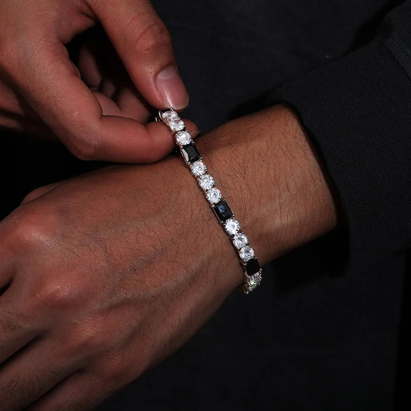 Person wearing a diamond bracelet on a dark background