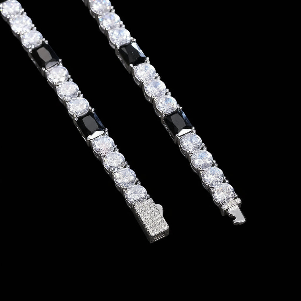 Diamond tennis bracelet with black and white gemstones on a blue background