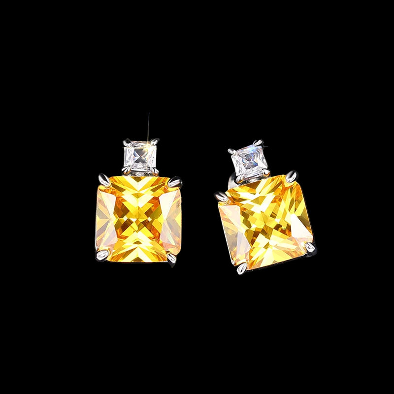 Pair of yellow gemstone earrings on a dark textured background