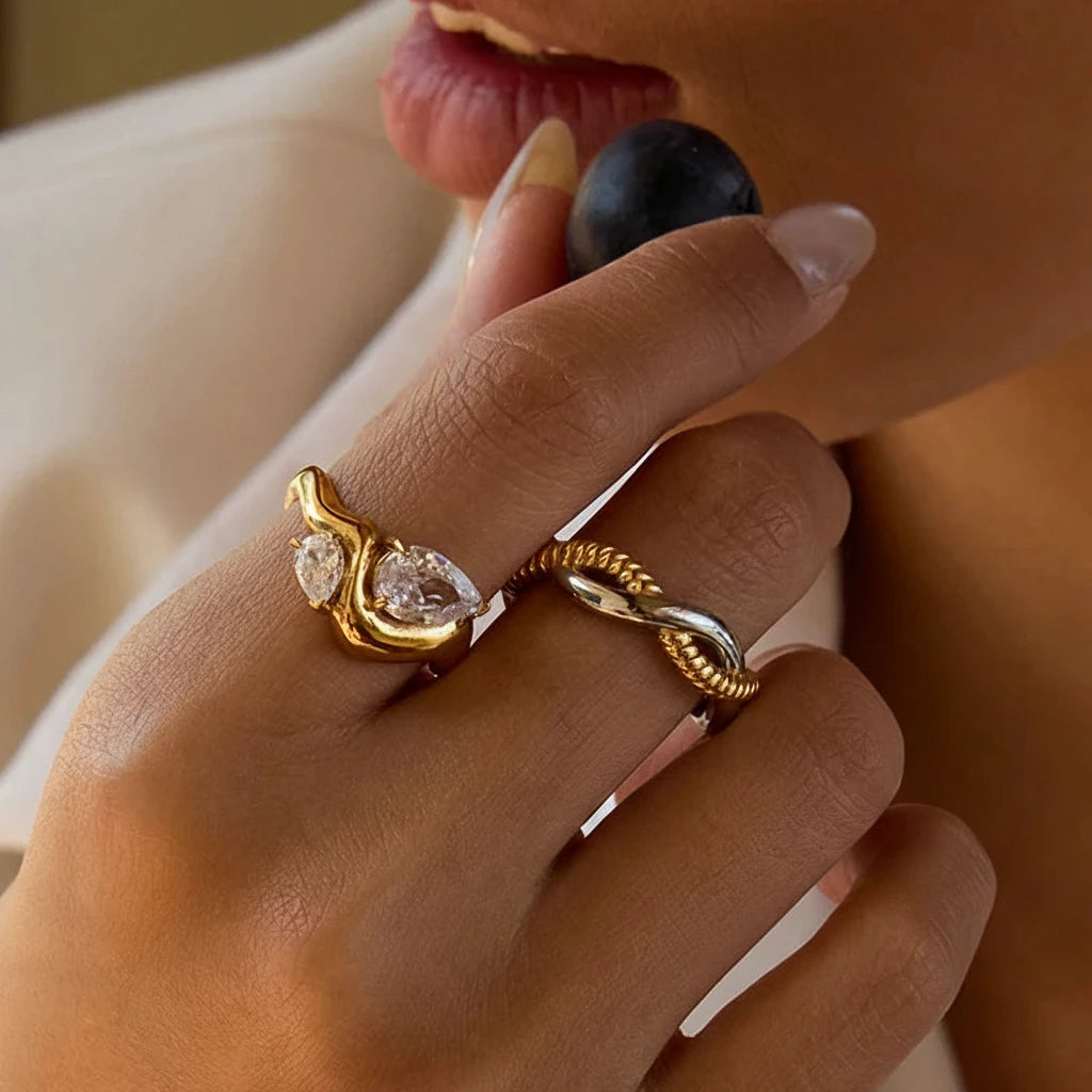 Close-up of a hand wearing two gold rings with diamond accents.